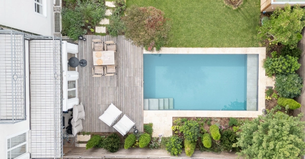 Living Pool Biotop von Oben mit klaren Wasser und einer Holzterrasse und Bepflanzung