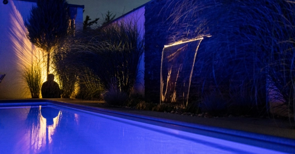 Ein Wasserfall am Pool mit Beleuchtung